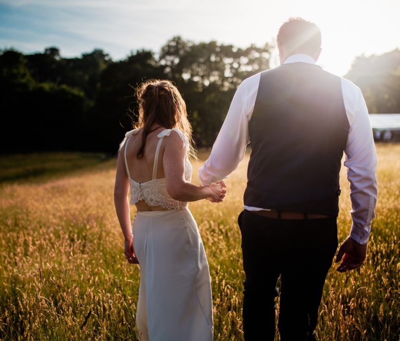 Happy married couple walking in field at Cuckoo Down Glamping in Exeter