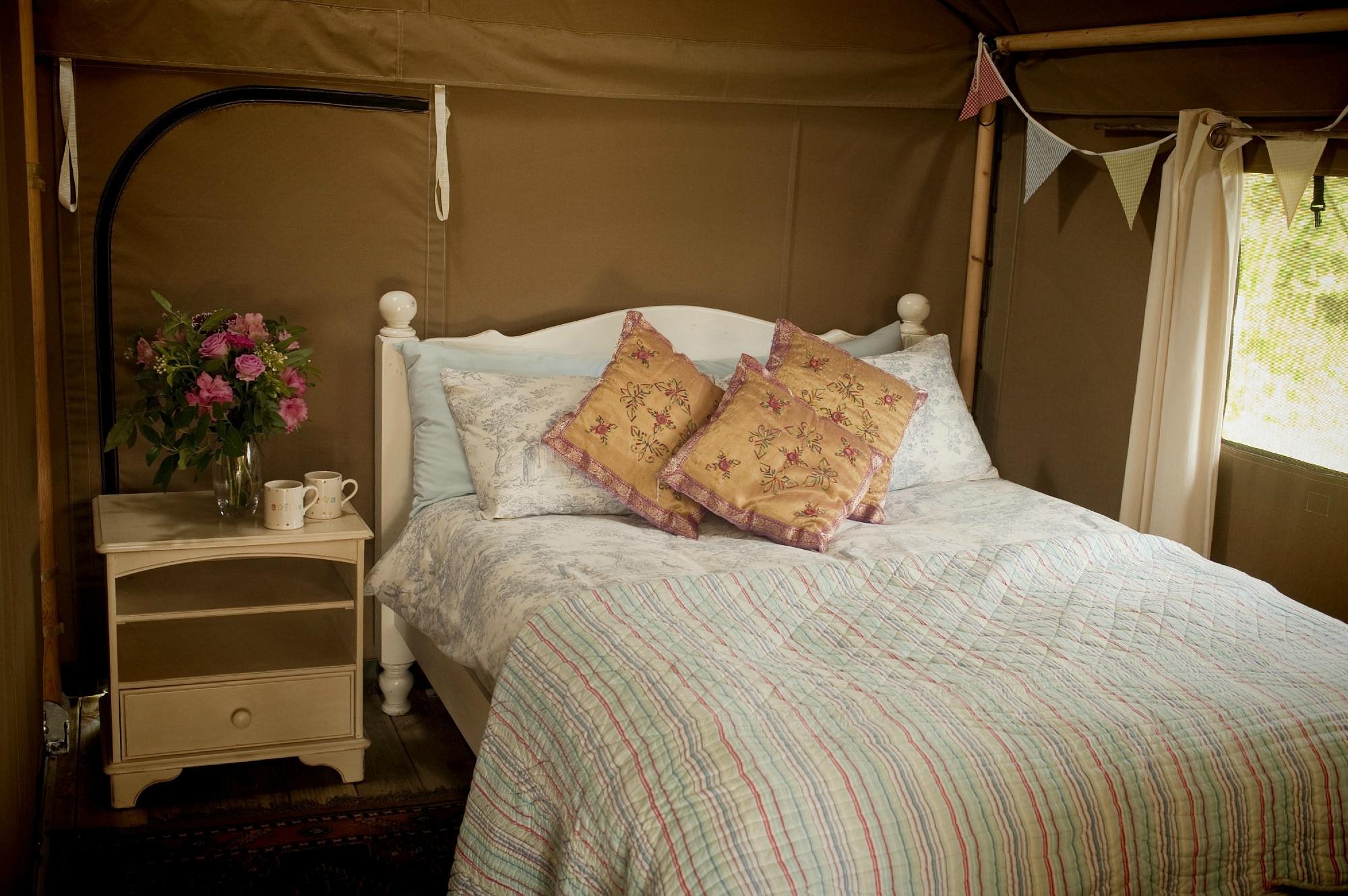 Double bed in glamping tent at Cuckoo Down Farm in Devon
