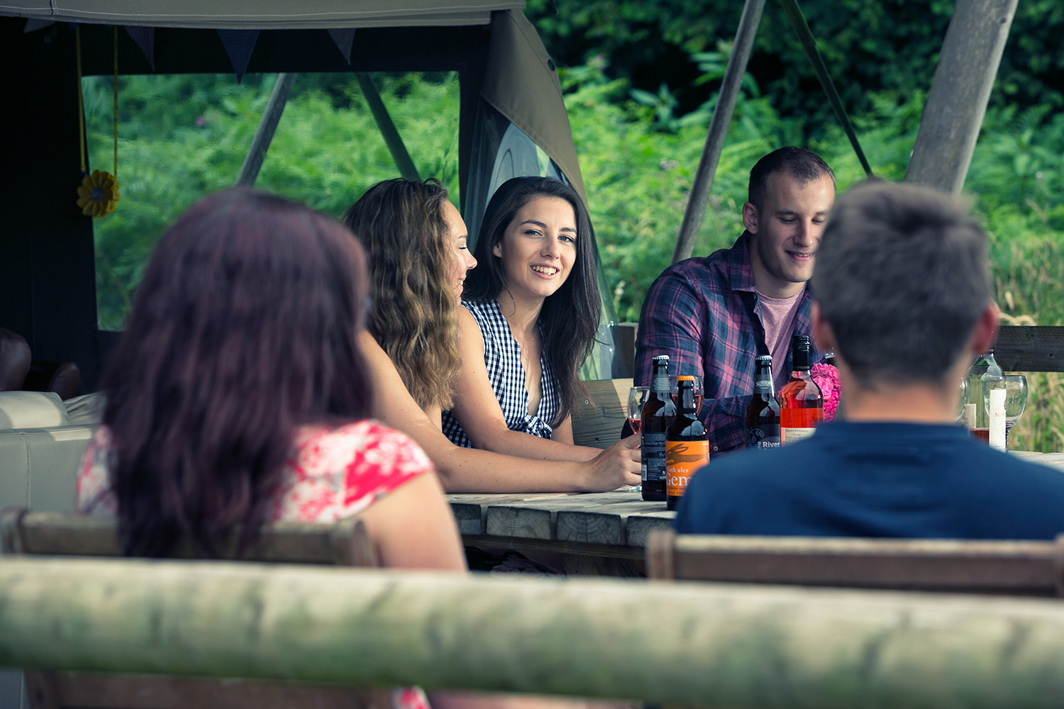 group of young people talking outside a glamping tent in devon