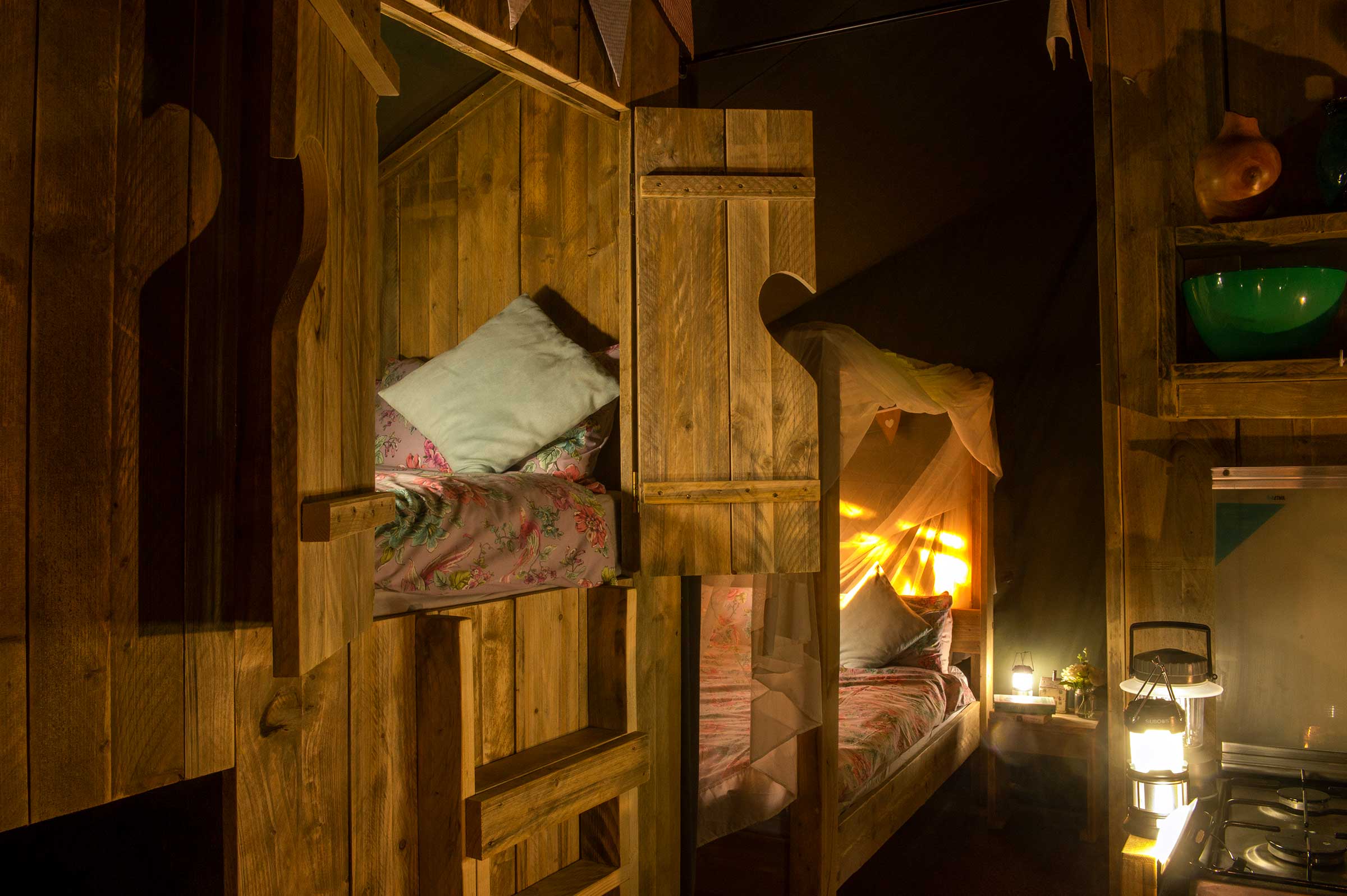 Inside of a glamping tent at night with lamps on